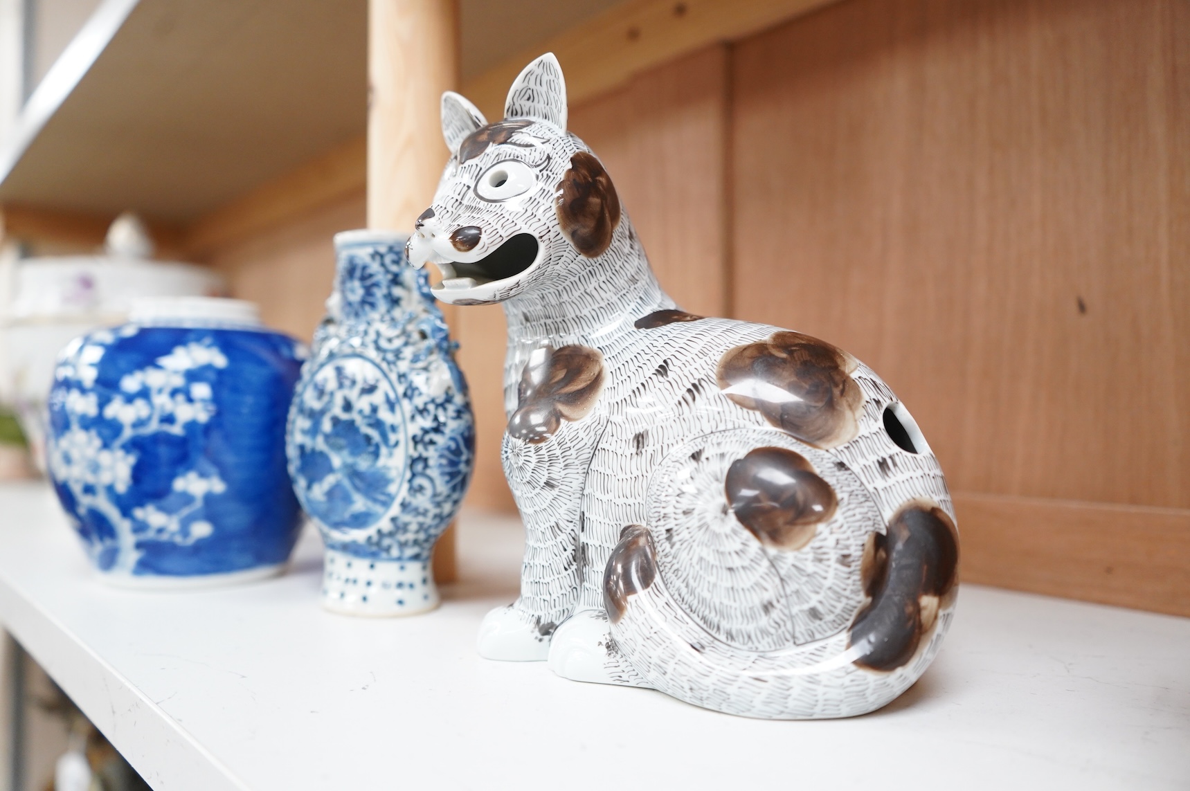 A 19th century Chinese blue and white small moon flask together with a later jar and a Portugese porcelain copy of a Chinese export cat, largest 19cm high